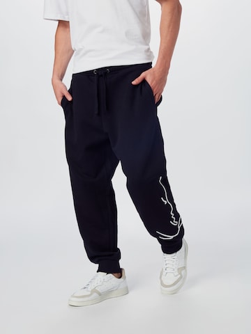 Karl Kani Tapered Trousers in Black: front