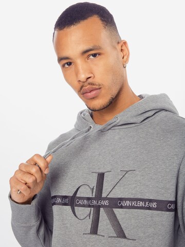 Sweat-shirt 'TAPING THROUGH MONOGRAM HOODIE' Calvin Klein Jeans en gris