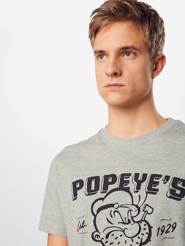 Merchcode - Camiseta 'Popeye Barber Shop' en gris