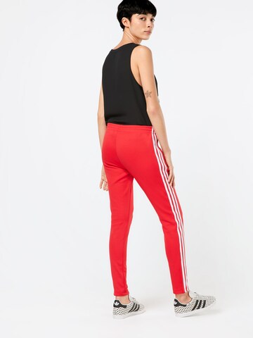 Coupe slim Pantalon ADIDAS ORIGINALS en rouge : derrière