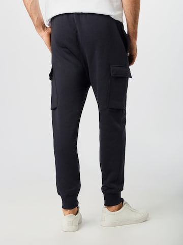 Effilé Pantalon cargo 'Club' Nike Sportswear en noir
