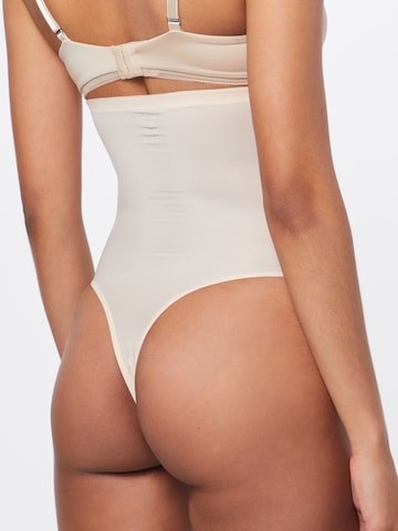 MAGIC Bodyfashion Regular Muotoilevat alushousut 'Hi-Waist Thong' värissä beige