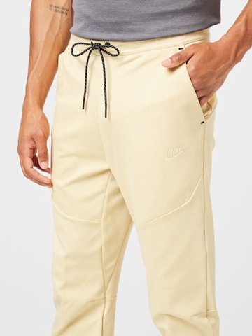 Tapered Pantaloni di Nike Sportswear in giallo
