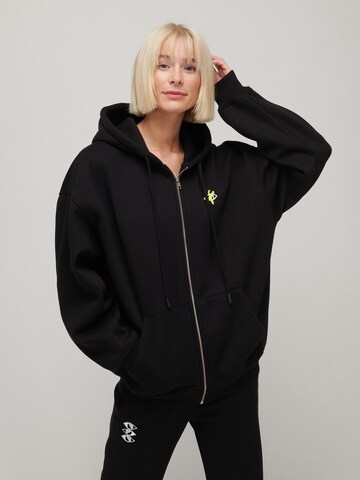 UNFOLLOWED x ABOUT YOU Zip-Up Hoodie 'GUEST LIST' in Black: front