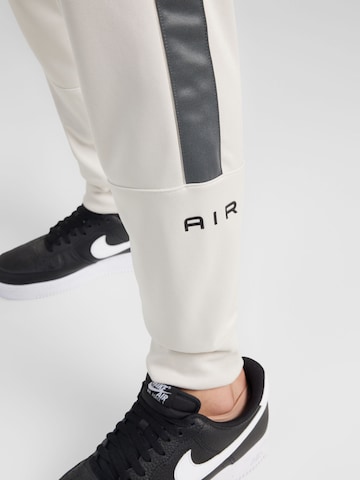 Nike Sportswear Szabványos Funkcionális nadrág 'AIR' - bézs