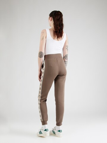 GUESS - Tapered Pantalón deportivo 'BRITNEY' en marrón