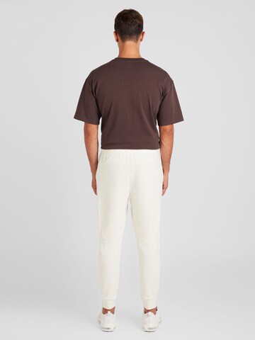 NIKETapered Sportske hlače 'PRIMARY' - bež boja