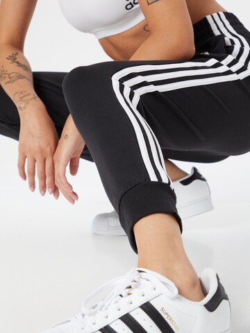 ADIDAS SPORTSWEAR Дънки Tapered Leg Спортен панталон 'Essentials 3-Stripes' в черно