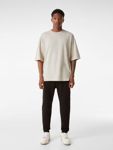 Bershka Tapered Byxa i svart