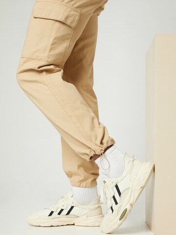 Kosta Williams x About You Regular Cargohose in Beige