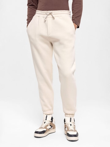 Antioch Tapered Trousers in Beige: front