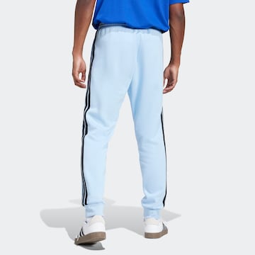 mėlyna ADIDAS SPORTSWEAR Siaurėjantis Sportinės kelnės 'Essentials'