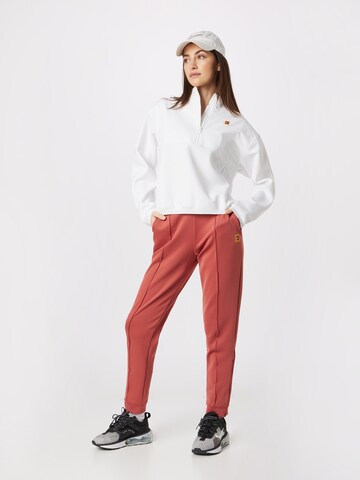 Tapered Pantaloni sportivi di NIKE in rosso