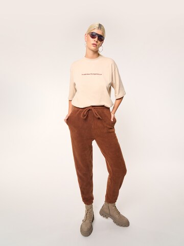 ABOUT YOU x Laura Giurcanu Tapered Pants 'Holly' in Brown