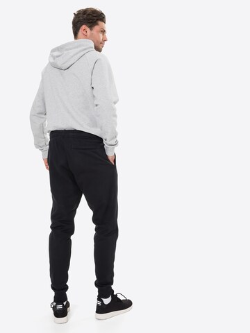 UNDER ARMOUR Tapered Urheiluhousut 'Rival' värissä musta