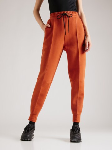 Nike Sportswear Alt kitsenev Püksid 'TCH FLC', värv oranž: eest vaates