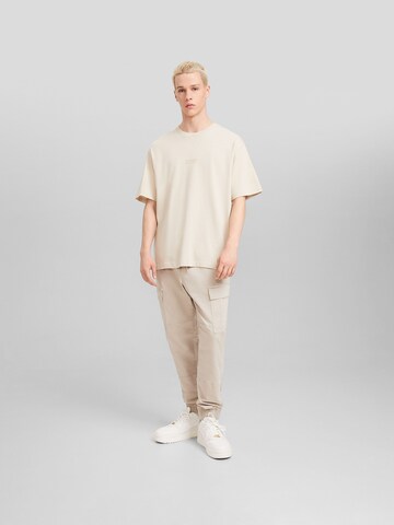 Bershka Tapered Cargo Pants in Beige