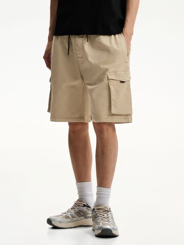 Bershka Loose fit Cargo trousers in Yellow: front