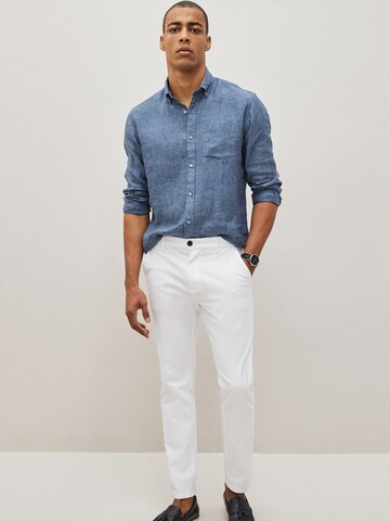 Next Slimfit Chinohousut värissä valkoinen