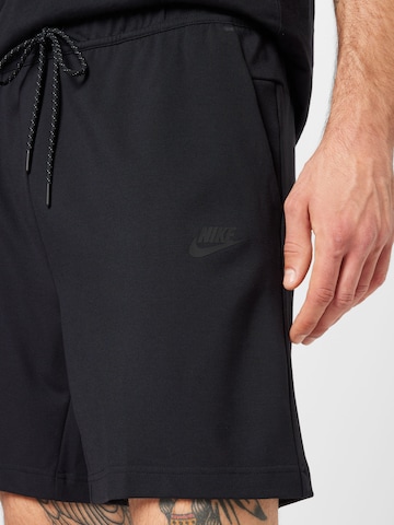 Nike Sportswear Ohlapna forma Hlače | črna barva