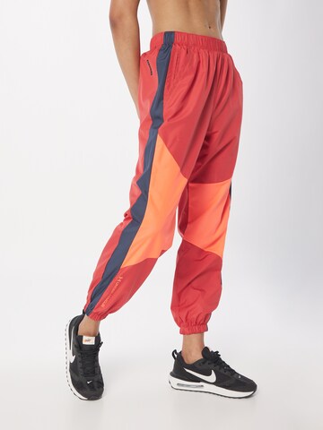 UNDER ARMOUR Tapered Sports trousers in Red: front