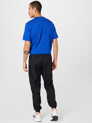 ADIDAS ORIGINALS Tapered Urheiluhousut värissä musta