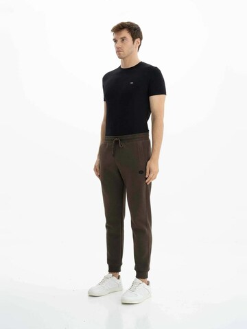 Arma Tapered Housut värissä ruskea
