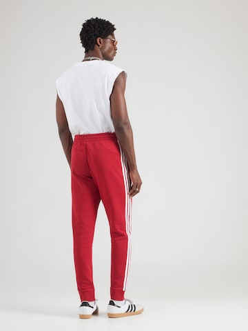 ADIDAS ORIGINALS - Tapered Calças em vermelho