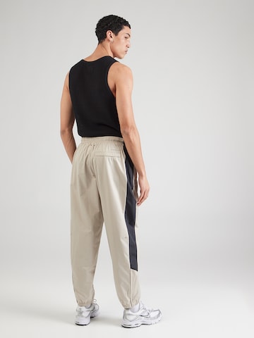 bēšs Nike Sportswear Pakapēniski sašaurināts piegriezums Bikses