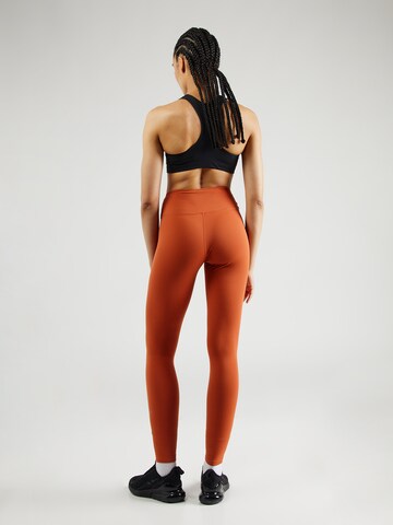 Skinny Pantaloni sportivi 'ONE' di NIKE in arancione