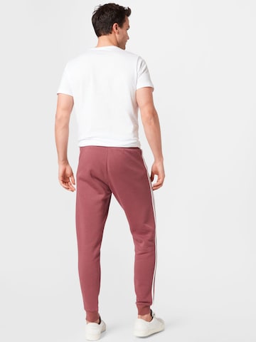 Tapered Pantaloni di ADIDAS ORIGINALS in rosso