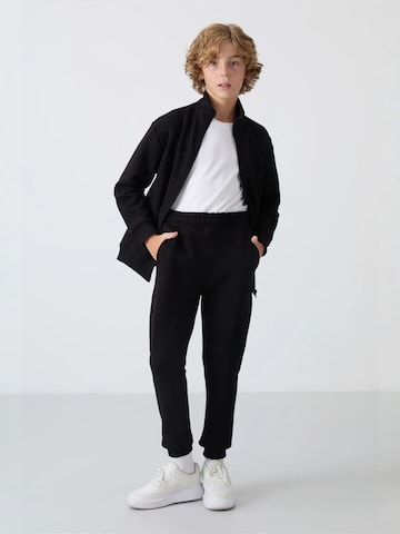 Tommy Life Trainingspak 'TOMMY Kinder Sport-Set' in Zwart: voorkant