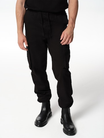 ABOUT YOU x Jaime Lorente Tapered Cargo Pants 'Adriano' in Black: front