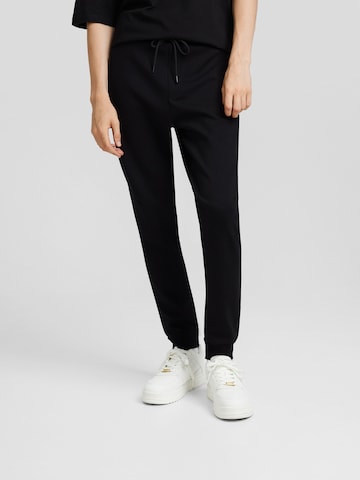 Bershka Tapered Housut värissä musta: edessä