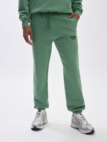 V!BE STUD!OS Tapered Trousers in Green: front