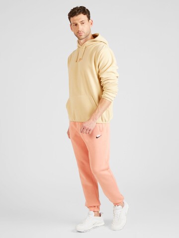 Nike Sportswear Zwężany krój Spodnie 'CLUB FLEECE' w kolorze pomarańczowy