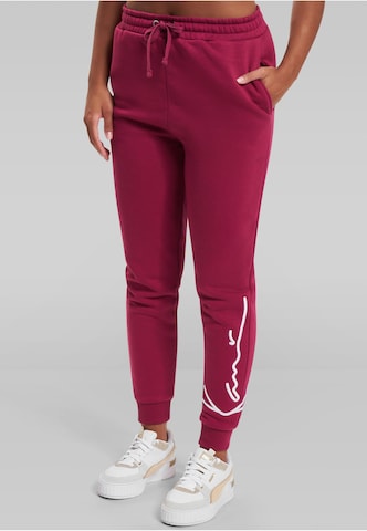 Karl Kani Tapered Pants 'Essential' in Red: front