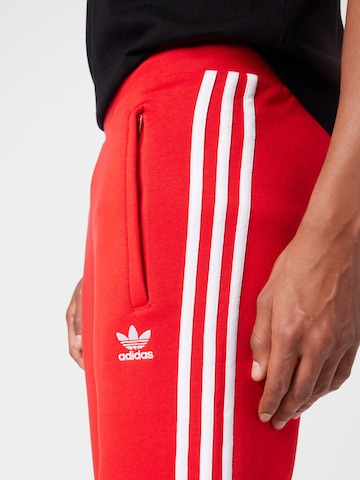 Tapered Pantaloni di ADIDAS ORIGINALS in rosso