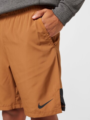 NIKE Normalny krój Spodnie sportowe w kolorze brązowy