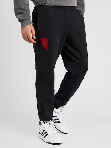 ADIDAS PERFORMANCE Tapered Workout Pants 'Manchester United Cultural Story' in Black: front