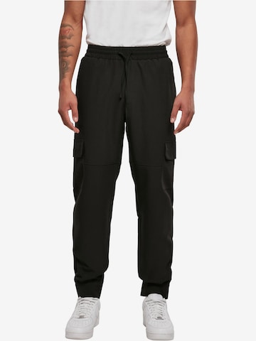 Urban Classics Tapered Cargo Pants in Black: front