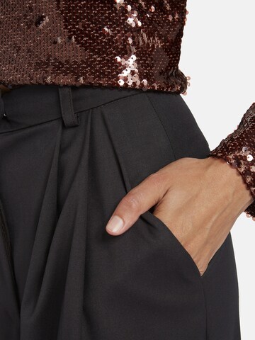 Nicowa Slimfit Anzughose 'ROSCIWO', weites Bein, Bundfalten, Model trägt Größe 34 in Braun