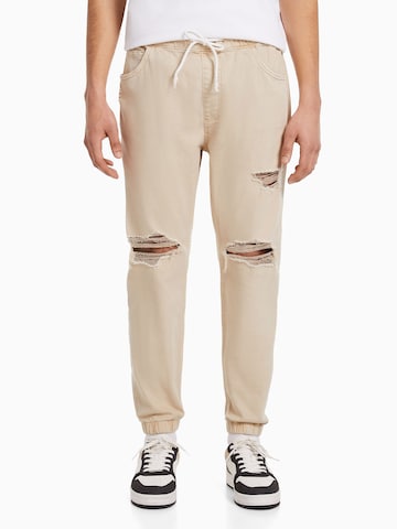 Bershka Tapered Jeans in Beige: predná strana