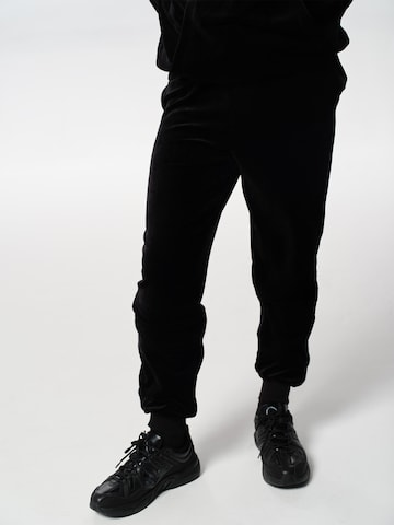 ABOUT YOU x Jaime Lorente Tapered Trousers 'Fernando' in Black: front