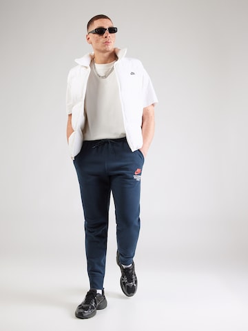 Nike Sportswear Tapered Byxa 'CLUB' i blå