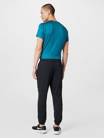 Effilé Pantalon de sport NIKE en noir