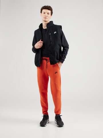 Nike Sportswear Tapered Παντελόνι 'TCH FLC' σε πορτοκαλί