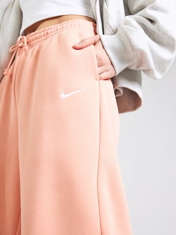 Tapered Pantaloni 'PHNX FLC' de la Nike Sportswear pe portocaliu