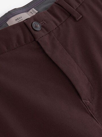 Next Slimfit Chinohousut värissä punainen
