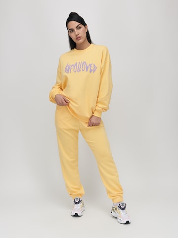 UNFOLLOWED x ABOUT YOU - Tapered Pantalón 'VIBE' en amarillo